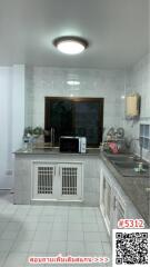 Compact fully tiled kitchen with modern appliances and ample cabinet space