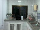 Compact fully tiled kitchen with modern appliances and ample cabinet space