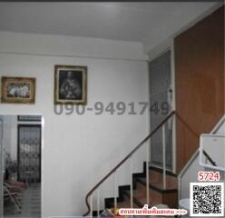 Interior view of a building entrance with staircase and security door