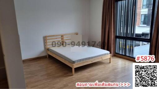 Minimalist bedroom with wooden bed and large window