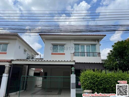 White two-story house with blue sky and clouds