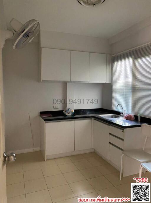 Compact modern kitchen with white cabinetry and a window