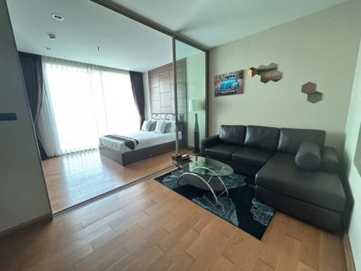 Modern living room with seamless bedroom view, featuring a comfortable seating area and natural light