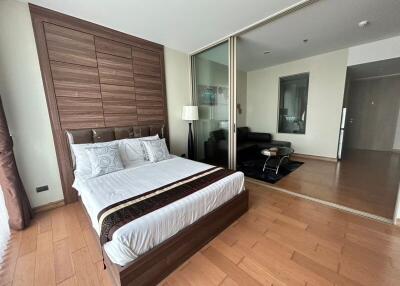 Spacious bedroom with large mirrored wardrobe and hardwood floors