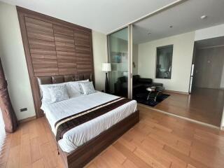 Spacious bedroom with large mirrored wardrobe and hardwood floors