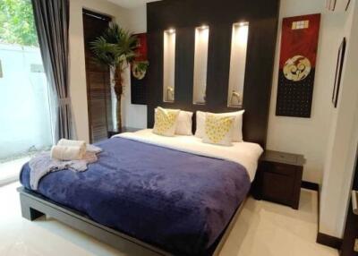 Modern bedroom with a well-made bed, side tables, and decorative wall art