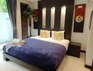 Modern bedroom with a well-made bed, side tables, and decorative wall art