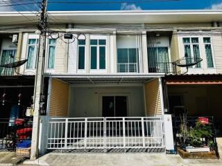 Modern townhouse front with balcony and gated entrance