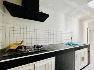 Modern kitchen with white tile backsplash and black cabinets