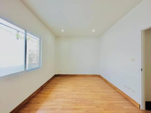 Bright empty bedroom with hardwood floors and natural light