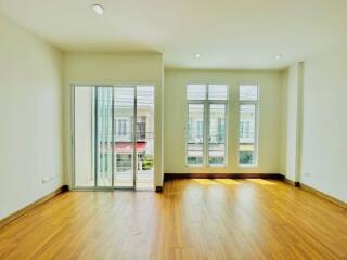 Spacious living room with hardwood floors and large windows