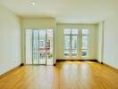 Spacious living room with hardwood floors and large windows