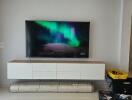 Modern living room with large television and staircase