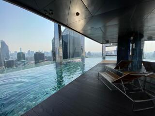 Rooftop infinity pool with a panoramic city view and a lounging area