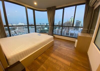 Spacious bedroom with large windows and panoramic city view