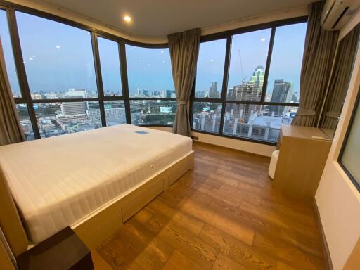 Spacious bedroom with large windows and panoramic city view