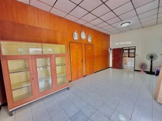 Spacious interior of a building with tiled floors, wooden paneling, and multiple doors