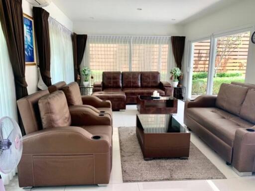 Spacious and well-furnished living room with ample seating and natural light