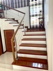Elegant staircase with wooden steps and modern stainless steel balustrade