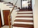 Elegant staircase with wooden steps and modern stainless steel balustrade