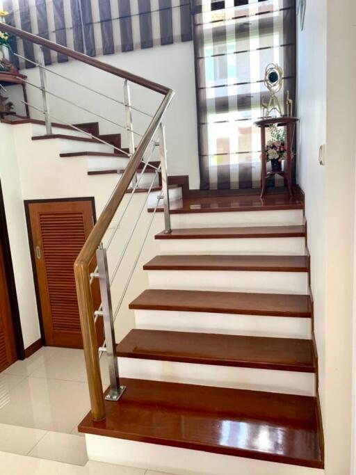 Elegant staircase with wooden steps and modern stainless steel balustrade