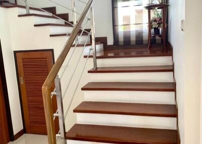 Elegant staircase with wooden steps and modern stainless steel balustrade