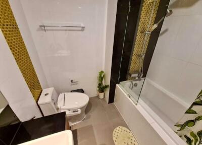 Modern bathroom with black and gold tiles, shower, and toilet