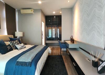Modern bedroom with a large bed, white and blue bedding, and minimalistic furniture