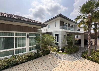 Spacious two-story residential home exterior with landscaped garden and driveway