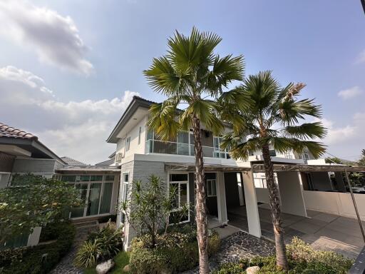 Spacious detached house with palm trees in the front yard under a clear sky