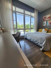 Bright and modern bedroom with floor-to-ceiling windows and hardwood floors