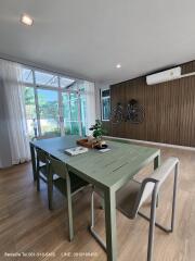 Modern dining room with green table and natural light