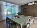Modern dining room with green table and natural light