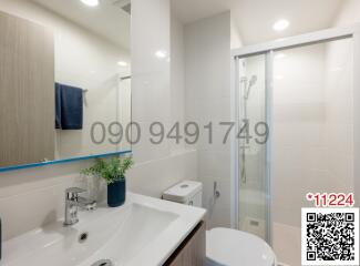 Modern white bathroom with glass shower enclosure and vanity