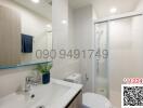 Modern white bathroom with glass shower enclosure and vanity