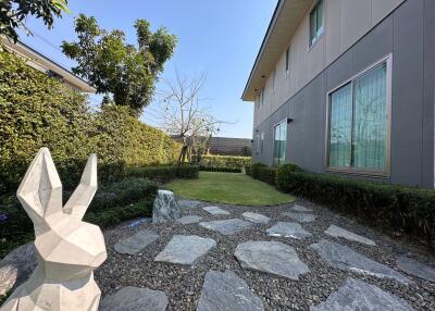 Modern house exterior with garden and artistic sculpture