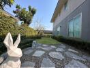 Modern house exterior with garden and artistic sculpture
