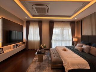 Modern bedroom with elegant interior design including a large bed, ambient lighting, and a television