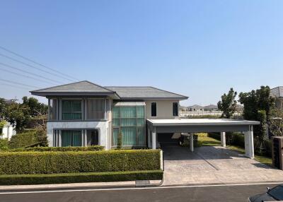 Modern two-story house with large windows and carport