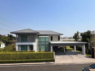 Modern two-story house with large windows and carport