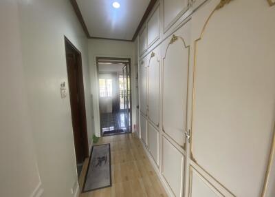 Bright hallway with wooden flooring leading to additional rooms