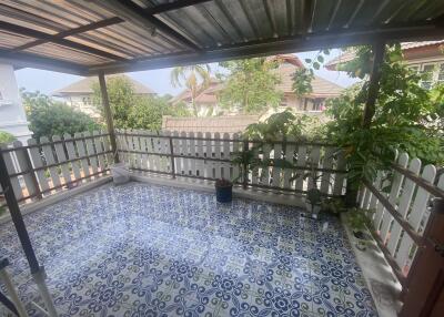 Spacious covered patio with patterned tile flooring and white fencing