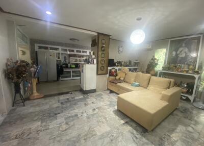 Spacious living room with marble flooring, comfortable seating, and open kitchen layout