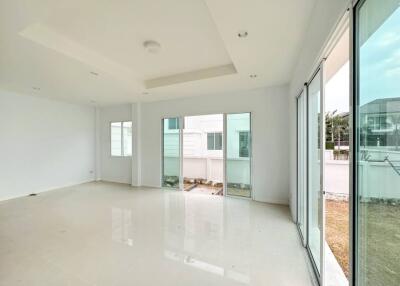 Spacious and bright empty living space with large windows and glossy tiled flooring
