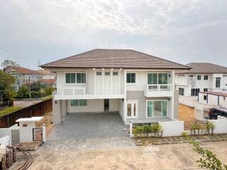 Modern two-story house with spacious driveway and balconies