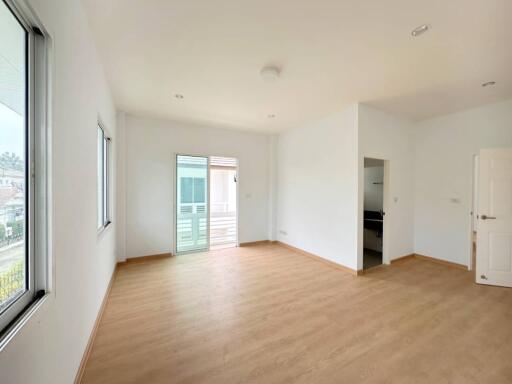 Spacious and well-lit empty living room with hardwood flooring