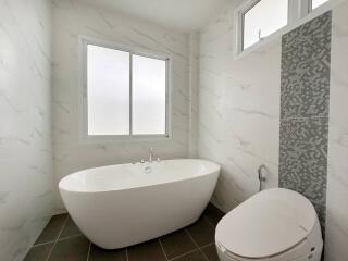 Modern bathroom with a freestanding tub and large window