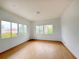 Spacious bedroom with large windows and hardwood floors