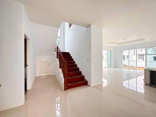 Spacious living room with staircase and ample natural light