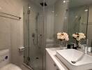 Modern bathroom with glass shower enclosure and sleek basin